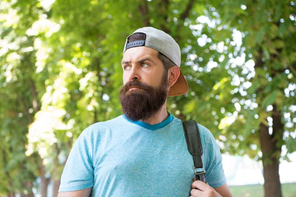 Hombre barbudo maduro con barba y bigote en camisa de verano y mochila de retención de gorra en el bosque, senderismo — Foto de Stock