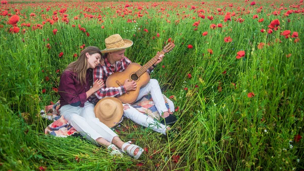 Forever love. couple with guitar. man and woman in poppy flower field. summer vacation. happy family. country music. spring nature beauty. love and romance. romantic relationship