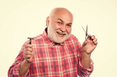 Kes ya da traş ol. Mükemmel uzunlukta ve sakalın şeklini seç. Olgun erkek berber, beyaz arka planda makas ve tıraş bıçağı tutar. Sakal ve bıyık kesiyorum. Tımar servisi. Sakalını kes.