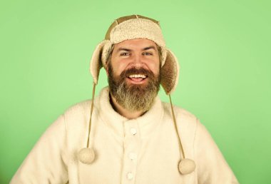 Hoş düşünceler. Erkek kış tarzı. Modern kış kulaklığı şapkası. Komik, mutlu, sakallı adam. Olgun bir adam komik kıyafetiyle poz veriyor. Kış şapkalı adam sakalı. Şapka giyen trend bir adamın portresi.