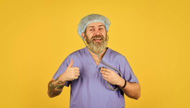 Bedava ilaçlar. Kalp krizini önle. Kalp atışlarını dinliyorum. Sağlık sigortası. Virüs konsepti. Adam hastanede çalışıyor. Sakallı doktor üniformalı steteskop. Tıbbi kontrol. Tıbbi yardım. Belirtileri izle