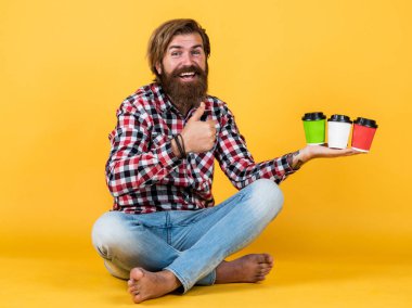 En iyi gün başlıyor. Teslimat. İlham almak için kahve lazım. Mutlu sakallı adam sabah kahvesini içiyor. Adam kağıt bardaktan sıcak çay içiyor. Günaydın. Enerjik sıcak içecek.