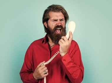 Beni sinirlendiriyorsun. Telefonda arkadaşınla konuş. Olgun erkek retro telefonu tutar. Sakallı ve bıyıklı adam çağrıya cevap veriyor. Telefon görüşmesi. Sakallı adam. Modern hayatta iletişim