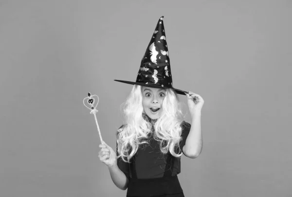 Feliz chica bruja de Halloween. un niño adolescente con sombrero de bruja. niño alegre utilizar varita mágica. hacer maravillas. fiesta de disfraces de carnaval. truco o trato. celebrar las fiestas. felicidad infantil — Foto de Stock