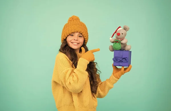 Шопоголик. Рождественские подарки онлайн. приготовься к Рождеству. С новым 2020 годом. крысиный символ года. маленькая счастливая девочка держит игрушку из мыши. вязанный свитер и игрушка в шляпе. магазин игрушек для детей — стоковое фото