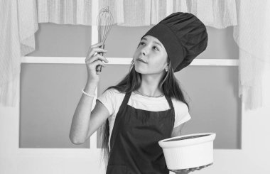 Gururun iştahı. Çocuk aşçı çırpıcıyla yemek yapıyor. Çocuk evde sağlıklı yemekler hazırlar ve aşçı üniforması giyer. Oda servisi ve ev işleri. Çocukluk gelişimi. Küçük kız mutfakta yemek pişiriyor.