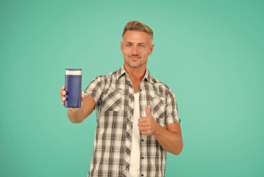 Tepeden tırnağa neşe içinde duş alın. Mutlu adam duş jeli şişesi için baş parmağını kaldırdı. Onaylanan el hareketi.