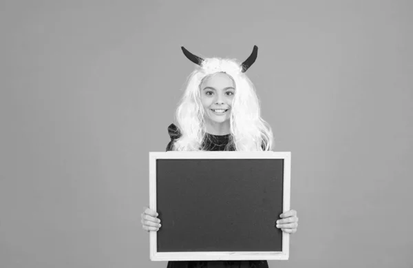 Halloween Teufelskind in Wichtelhörnern hält Schulkreidetafel für Kopierraum, fröhliches Halloween — Stockfoto
