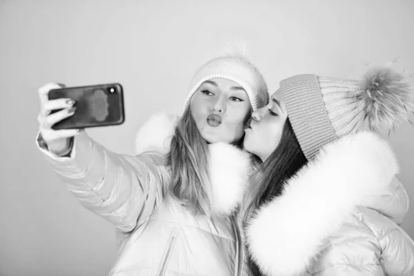 Gorgeous girls makeup faces cuddling. Selfie time. Female fashion. Girls friends having fun. Emotional women in jackets. Friends hang out together. Female clothes shop. Modern trendy female outfit