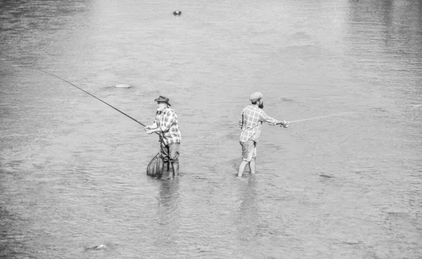 Profundo en el agua. pasatiempo y actividad deportiva. Cebo para truchas. dos pescador feliz con caña de pescar. Pesca de caza mayor. amistad masculina. padre e hijo pescando. aventuras. recreación y ocio al aire libre —  Fotos de Stock