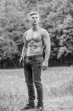Enerji dolu. Ormanda vahşi ve çekici bir erkek. Vücut geliştirici kaslarını gösterir. Güç ve güç. Oduncu baltayı taşır. Güçlü bir vücut. Baltalı kaslı adam. Seksi maço çıplak gövde baltası