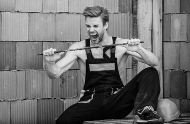 Yeterince güçlü. Adam metal iskeleti bükmeye çalışıyor. İnşaat. Metal işleriyle uğraşan bir mühendis. Mimar, tamirci. İş kıyafetleri içinde işçi. Güçlü ve güçlü hissediyorum. Güçlü duygusal adam.