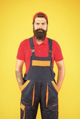 Üniformalı vahşi sakallı adam. Tulumlu ve şapkalı adam. Erkek işçi inşaatçı ya da mühendis. Olgun tamirci servisi. Yetenekli tesisatçı. İşi bitirdikten sonra tamirci