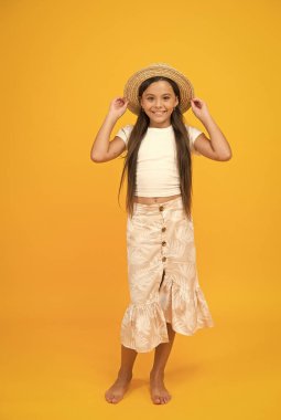 Onun kişisel tarzı. Yaz tatilini seviyor. Tatil zamanı. Mutlu ve tasasız hisset. Hasır şapkalı sevimli gülümseme. Mutlu çocukluk kavramı. Küçük kızın uzun ve sağlıklı saçları var. çocuk güzelliği ve moda