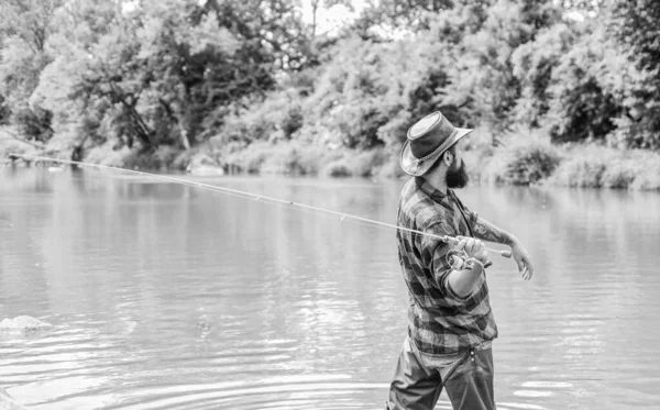 Historias de peces contadas aquí. pasatiempo y actividad deportiva. pothunter. Pescador barbudo en el agua. fin de semana de verano. Pesca de caza mayor. hombre maduro pesca con mosca. hombre pescando peces. pescador con caña de pescar — Foto de Stock