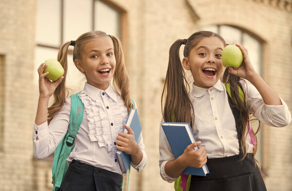 Учащиеся одноклассницы с рюкзаками, обедающие в школе, голодные дети