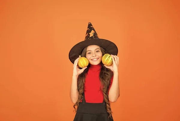 Gelukkig meisje op Halloween dragen heks carnaval kostuum indoor holding pompoen, halloween feest — Stockfoto