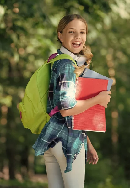 Vaše vzdělání je po vašem. Šťastné dítě nosí knihy a batoh venku. Školní vzdělání. Studium a vzdělání. Aktivní učení. Duševní vývoj. Nenucený módní styl. Dětské roky — Stock fotografie