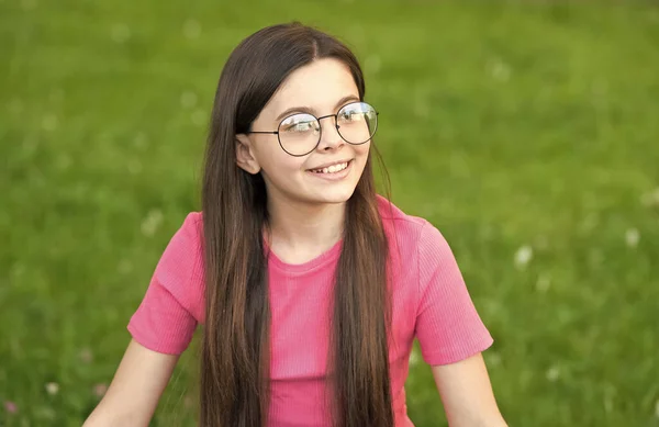 Little girl wear vintage rim eyeglasses green lawn background, fresh air concept — Stock Photo, Image