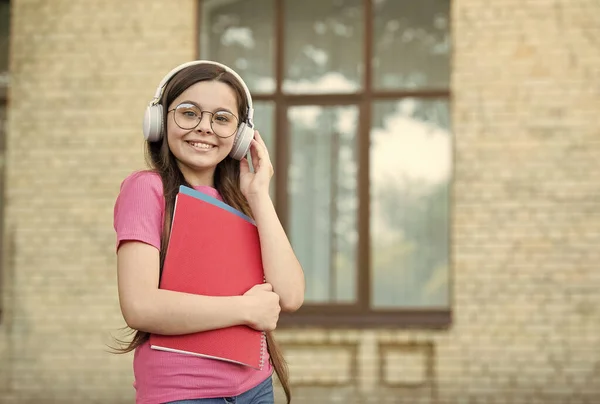 Poslouchej, co chceš. Šťastné dítě nosí sluchátka venku. Poslouchejte technologie. Poslouchám porozumění. Anglická škola. Moderní životní styl. Zvukové kurzy. Jazyk je budoucnost, kopírovací prostor — Stock fotografie