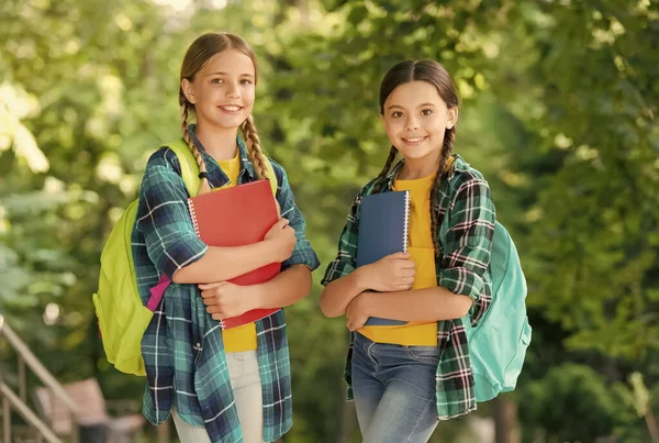 Χαριτωμένα παιδιά σε casual στυλ μόδας με έξυπνη εμφάνιση μεταφέρουν βιβλία μελέτης και σχολικές τσάντες φυσικό τοπίο, μετά το σχολείο — Φωτογραφία Αρχείου