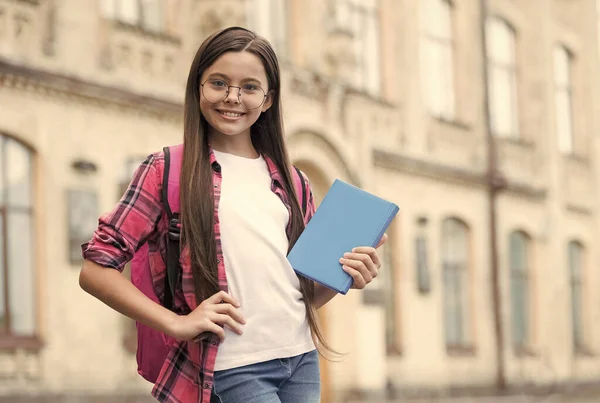 Glückliches Kind in lässiger Art und Weise halten Lesebuch für die Schulstunde, Bildung — Stockfoto