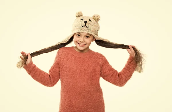 Ζεστά ρούχα και αξεσουάρ μόδας για παιδιά. Χαρούμενη παιδική δραστηριότητα. Κοριτσάκι με καπέλο από πτερύγιο αυτιού. Χειμερινές διακοπές θαύμα. παιδικό πλεκτό καπέλο που απομονώνεται σε λευκό. κρύος χειμώνας — Φωτογραφία Αρχείου