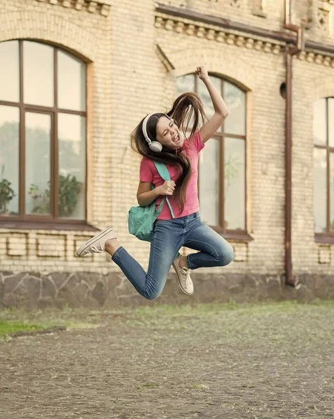 Энергичная девочка, прыгающая с парашютом, слушающая музыку в наушниках, неудержимая забавная концепция — стоковое фото