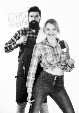 Tam bir barbekü tabağı. Sakallı hippi ve kız ızgara çatal bıçaklarını beyaz arka planda tutuyorlar. Piknik ve barbekü. Aile barbeküye hazırlanıyor. Barbekü tekniği. Birlikte yemek pişirmek.