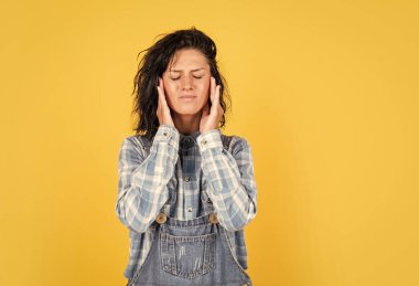 Migren ağrısı. Kareli gömlek giyen bir kadın. Kadın güzelliği ve sağlığı. Sağlıklı yaşam kavramı. hippi yaşam tarzı. Kot pantolon giymiş mutsuz bir kadın. hippi kızın başı ağrıyor.