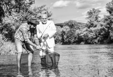 Mutlu balıkçı arkadaşlığı. Yakalama ve balık tutma konsepti. İki erkek arkadaş birlikte balık tutuyor. Emekli baba ve sakallı oğul. İş adamının uçan balık hobisi. emeklilik balıkçılığı. Mutlu aile birlikte