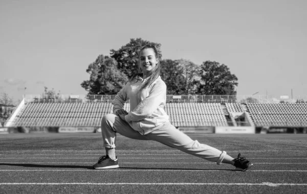 Biegacz przygotować się do wyścigu konkurencji. sprinter rozgrzewa się na stadionie siłowni. elastyczność. szkolenie dzieci na lekcjach wychowania fizycznego. Nastolatka rozciągająca się przed ucieczką. Utrzymanie kondycji i zdrowia — Zdjęcie stockowe