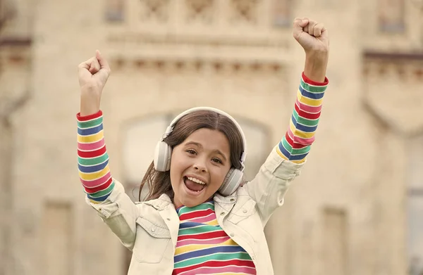 Fröhliches, energisches Mädchen hört Musik, moderne Kopfhörer, tanzendes Kinderkonzept — Stockfoto