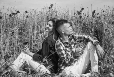 Erkek ve kızın gelincik çiçekli tarlada romantik bir randevusu var gitar ve şarap eşliğinde.