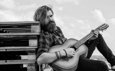 Müzik için mükemmel bir yer. Modern görünümlü sakallı, akustik gitarlı hippi. Bıyıklı vahşi yakışıklı adam gitar çalıyor. Olgun müzisyen ve şarkıcı. Sıradan stil gitarist.