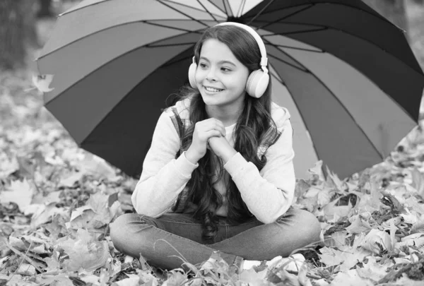 Sentirse protegido. niño de otoño bajo paraguas colorido. sentir la inspiración. Feliz infancia. de vuelta a la escuela. chica con auriculares en el parque. disfrutar de la caída en el bosque. escuchar música. cursos en línea educación — Foto de Stock