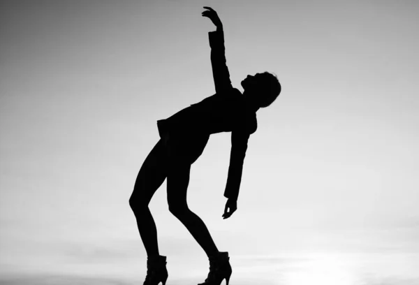 日没の女性のシルエット。女は暗闇で踊る。ダークフィギュア。夕暮れ時に踊る女の子 — ストック写真