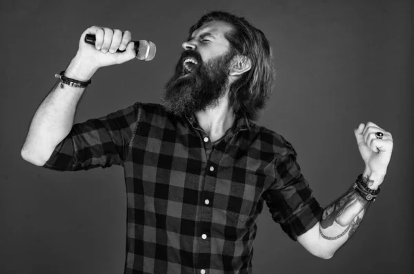 Face à la musique. Un bel homme brutal avec des moustaches chantant. mature gars chanter chanson dans microphone. karaoké. mode décontractée chanteuse de style. moderne look hipster barbu avec micro — Photo