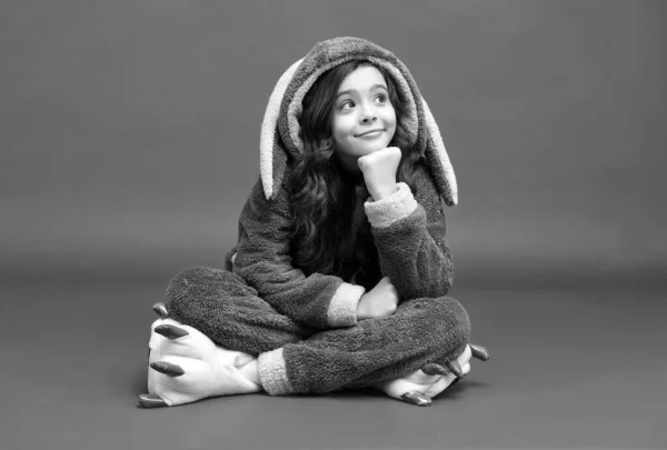 Lindo como conejito. Niño pequeño usa pijama de conejo sentado fondo rojo. Día de Pascua. Primavera — Foto de Stock