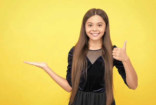 Glücklich Teenager Mädchen präsentiert Produkt und zeigt Daumen nach oben Geste, Kopierraum, Werbung — Stockfoto