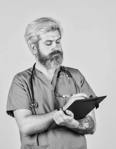 Medical history and prescription. Professional doctor holding folder. mature bearded nurse holding clipboard. male medical doctor use stethoscope. therapist in uniform at hospital — Stock Photo, Image