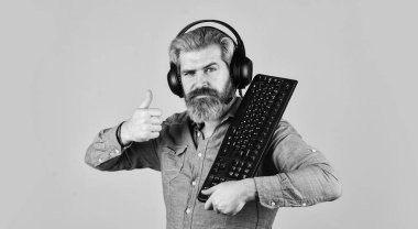 Çevrimiçi Video Oyunu. Siber Şampiyonluk. Çevik iş. İnternetten müzik indiriyorum. Sakallı adam kulaklıkları ve klavyesi. Profesyonel Oyuncu Arcade bilgisayar oyunu oynuyor. çevrimiçi sohbet
