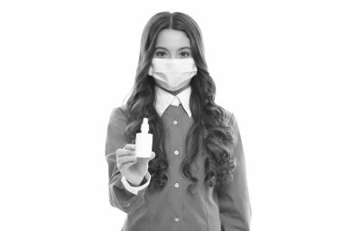 Koronavirüse karşı koruyucu maskeli sağlıklı bir çocuk covid pandemik ve karantina sırasında burun damlası sunar.