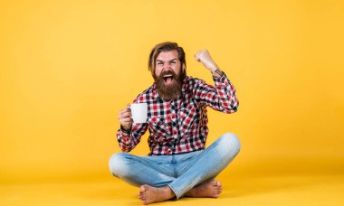 Kazandım. Enerjik, sıcak bir içecek. İlham için biraz kahveye ihtiyacım var. Güne mükemmel bir başlangıç. Mutlu sakallı adam sabah kahvesini içiyor. Adam fincandan sıcak çay içiyor. Günaydın sana.