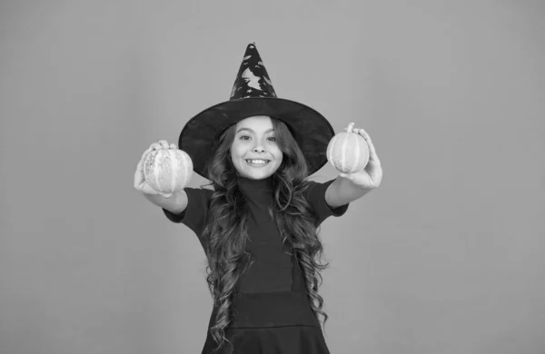 Fröhliches Kind im Hexenhut-Kostüm zu Halloween mit kleinem gelben Kürbis, traditionellem Halloween — Stockfoto