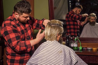 Kendini uyarılmış say. Uzun sarı saçlı adam, dikiz aynasından bakıyor. Saç kes. Berber, sakallı adam için kuaförlük yapıyor. Hipster müşteri saçını kestiriyor. Berber makası