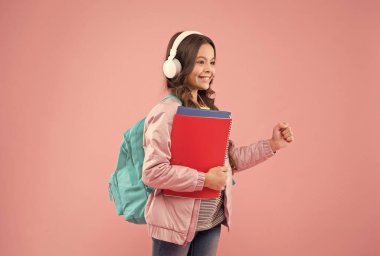 Öğrenmenin yeni perspektifi. Mutlu çocuk okula pembe arka planda dönüyor. Küçük çocuk elinde bir şey tutuyormuş gibi yapıyor. 1 Eylül. Bilgi toplama günü. Eğitim ve öğrenim. Okul yılı başlangıcı, kopyalama alanı