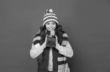 Alışverişin tadını çıkar. Hediyeli yün elbiseli genç kız. Sıcak giysi trendleri. çocukluk mutluluğu. Örgü giysili çocuk hediye kutusunu tutuyor. Tatil için hazırım. Boks günü. Sonbahar mevsimi modası