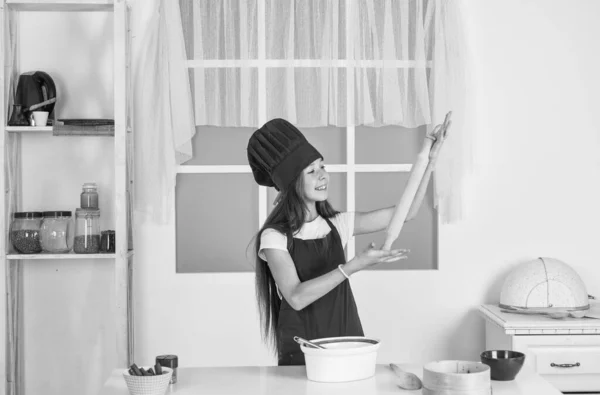 Criança preparar comida saudável em casa e vestindo uniforme de cozinheiro. limpeza e ajuda em casa. desenvolvimento infantil. menina pequena assar na cozinha. chef criança cozinhar com rolo de pino. Merece bem. — Fotografia de Stock