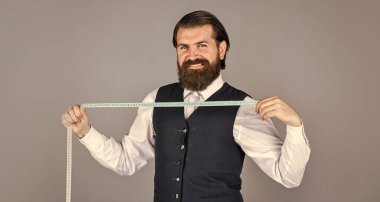 Fikirleri kıyafete dönüştürmek. Erkek kıyafetleri terziliği yapan adam. Vahşi adam moda tasarımcısı. Adam erkekler için kostüm tasarlıyor. Sartor çalışmaya hazır. Resmi ve ofis tarzı. Mezuralı terzi.